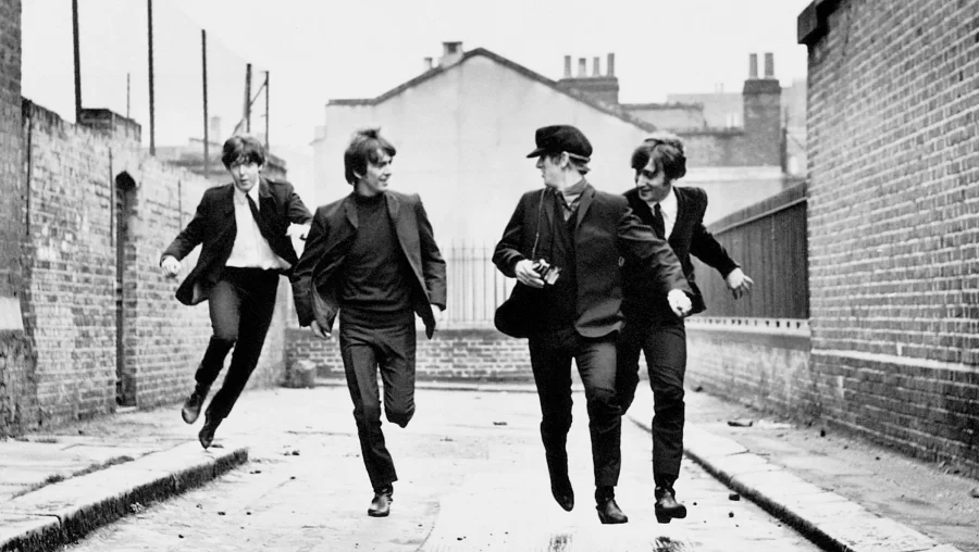 The Beatles acting as though they are running from fans for the cover of the film A Hard Days Night