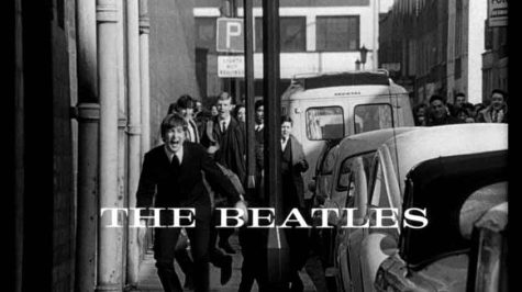 The Beatles are being chased down by a hoard of fans on a sidewalk and the title A Hard Day's Night is in front on them