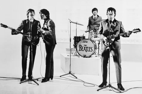 The Beatles preforming at a televised concert (Left to Right) Paul McCartney on bass, George Harrison as lead guitar, Ringo Starr on drums, and John Lennon as rhythm guitar.